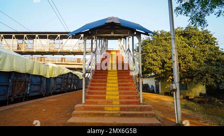 Vom Bahnhof aus geht man über die Treppe zur Brücke, von innen aus blickt man auf den Bahnhofskorridor, von einer Treppe über die Brücke bei einer ländlichen Bahnstunde Stockfoto