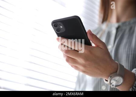 MYKOLAIV, UKRAINE - 16. MÄRZ 2020: Frau mit iPhone 11 Black in Innenräumen, Nahaufnahme Stockfoto