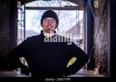 Teplitz, Deutschland. 26. Januar 2023. Der Gründer von Nordwolle, Marco Scheel, steht in der Scheune aus Feldstein, die gerade renoviert wird. In den nächsten Monaten sollen hier die Werkstätten für die Herstellung von nachhaltiger Funktionsbekleidung aus Wolle pommerischer Schafe eingerichtet werden. 2018 verlegte Scheel sein Unternehmen, das er zwei Jahre zuvor auf der Insel Rügen gegründet hatte, nach Teplitz und war in den Medien für seinen Kampf gegen die Behörden um die erforderlichen Baugenehmigungen bekannt geworden. Kredit: Jens Büttner/dpa/Alamy Live News Stockfoto