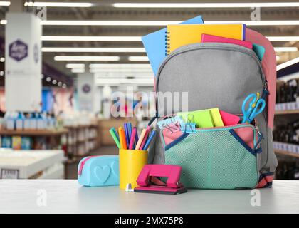 Heller Rucksack mit Schulpapier auf dem Tisch im Einkaufszentrum Stockfoto