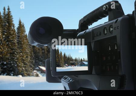 Wunderschöne Aussicht auf verschneiten Wald mit einer professionellen Videokamera aufnehmen Stockfoto