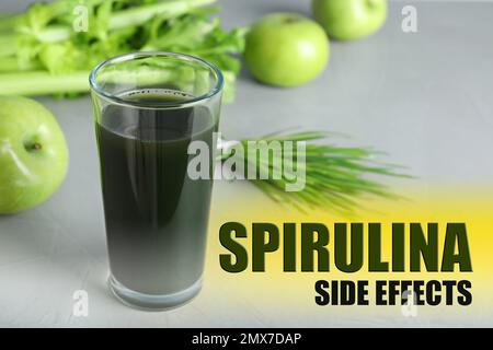 Ein Glas Spirulina-Getränk auf grauem Hintergrund. Nebenwirkungen Stockfoto