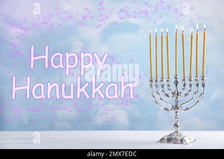 Silberne Menora auf weißem Holztisch. Frohes Chanukka! Stockfoto