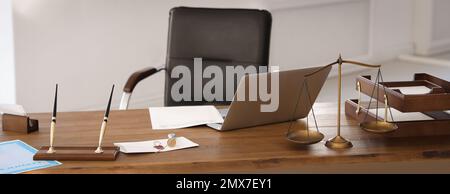 Waagen der Justiz, Laptop und Wachsstempel auf dem Schreibtisch im Anwaltsbüro. Bannerdesign Stockfoto