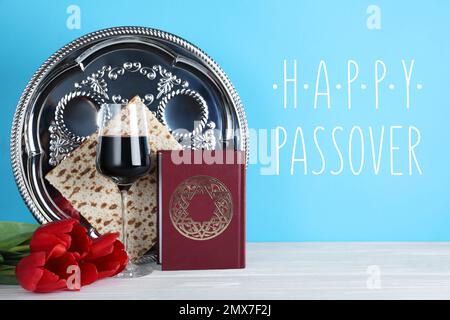 Symbolische Pesach (Passover Seder)-Gegenstände auf weißem Holztisch Stockfoto