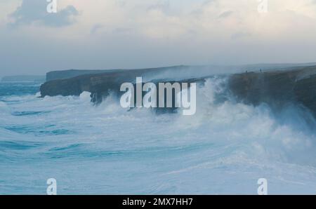 Menschen, die im Wintersturm auf den Yesnaby-Klippen spazieren, Orkney-Inseln Stockfoto