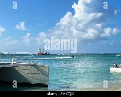 Segelboote und Wassermotorräder auf dem karibischen Meer vor der Küste von Aruba. Stockfoto