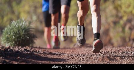 Laufschuhe für Läufer beim Traillauf. Die Beine von Ultra-Running-Athleten nähern sich dem Laufen auf dem Rock Path Trail Stockfoto