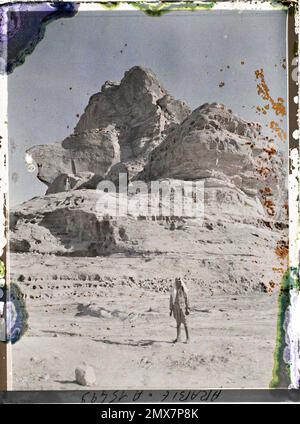 (Französisch - Quweira , Arabie ( actuelle Jordanie ) UN homme pose sous une falaise). Stockfoto