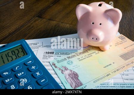 Steuerrückerstattung mit pinkfarbenem Sparschwein und Taschenrechner Stockfoto