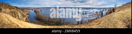 Frühlingslandschaft, Panorama, Banner - Flut im Flusstal, der gewundene Fluss über den Wiesen zwischen Hügeln und Wäldern, im Nordosten der Ukraine Stockfoto