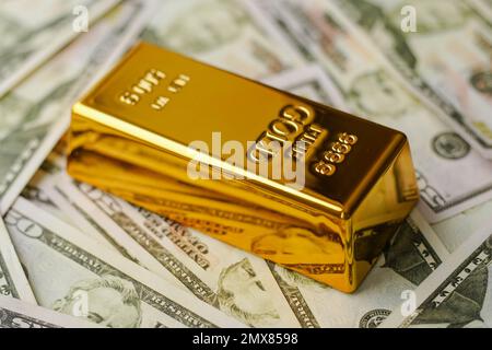 Goldbarren auf US-Dollar-Banknoten. Goldbarren für Investitionen kaufen. Stockfoto