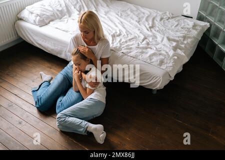 Aus dem Blickwinkel einer liebevollen Mutter, die ein verletztes, kleines Kind tröstet, Liebe und Fürsorge zeigt, Unterstützung ausdrückt, sich umarmt Stockfoto