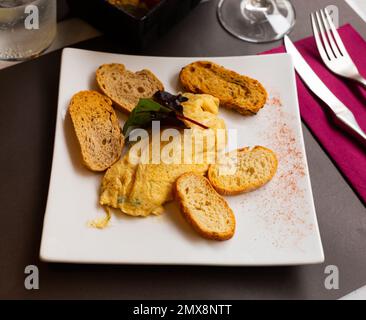 Einfaches Eieromelett mit Kräutern auf dem Teller, Nahaufnahme Stockfoto