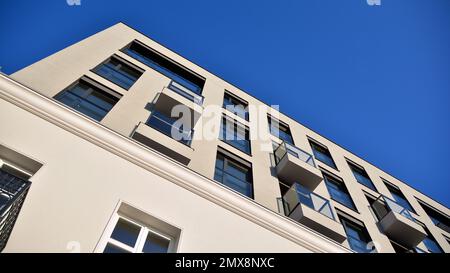 Außenansicht eines modernen mehrstöckigen Apartmentgebäudes mit Fassade, Fenstern und Balkonen. Stockfoto