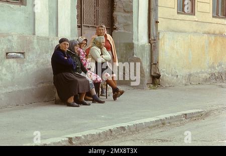 Kreis Sibiu, Sozialistische Republik Rumänien, ca. 1978. Ältere Frauen, die auf einer Bank an einer Dorfstraße sitzen. Stockfoto