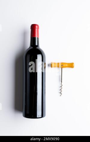 Flasche Rotwein und Korkenzieher auf weißem Hintergrund, mit Kopierbereich Stockfoto