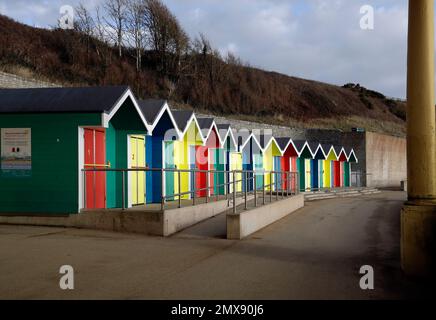 Farbenfrohe, hell bemalte Holzhütten auf Barry Island, außerhalb der Saison eingesperrt. Januar 2023. Im Winter Stockfoto