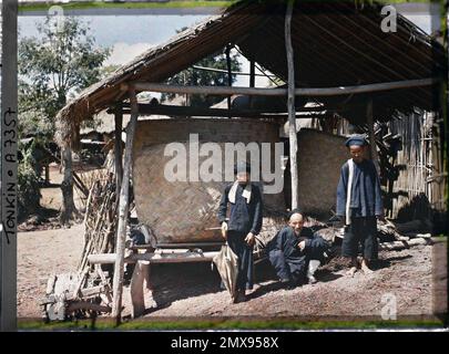 Cay-Sau, Umgebung von Bac-Lé, Tonkin, Indochine der Dorfbewohner Thô (Thai), blau gekleidet, vor einem Dachboden in Paddy, Léon in Indochina Stockfoto