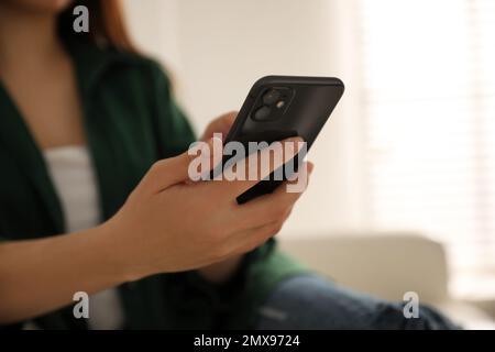 MYKOLAIV, UKRAINE - 16. MÄRZ 2020: Frau mit iPhone 11 Black in Innenräumen, Nahaufnahme Stockfoto