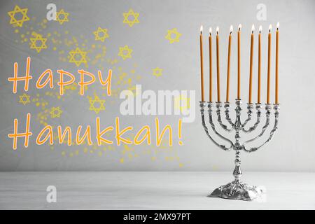Silberne Menora auf weißem Holztisch. Frohes Chanukka! Stockfoto