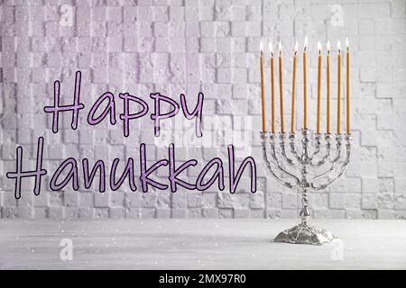 Silberne Menora auf weißem Holztisch. Frohes Chanukka! Stockfoto
