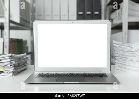 Moderner Computer mit leerem Bildschirm auf dem Tisch im Büro. Raum für Design Stockfoto