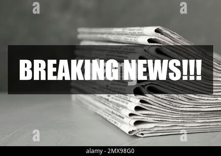 Phrase Breaking News und Zeitungsstapel auf einem Tisch aus hellgrauem Stein. Journalistenarbeit Stockfoto