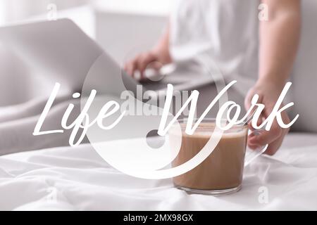 Eine Frau mit Laptop, die morgens Kaffee im Schlafzimmer trinkt, Nahaufnahme. Konzept der Vereinbarkeit von Arbeit und Leben Stockfoto
