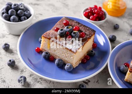 Teller mit Hüttenkäse-Auflauf und Beeren auf hellem Hintergrund Stockfoto