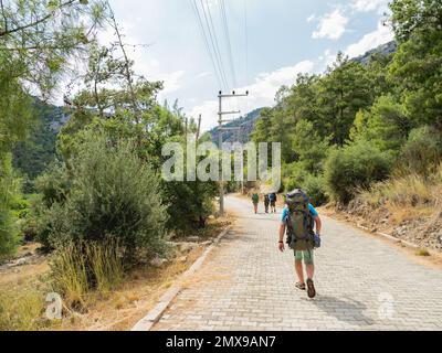 Touristen mit Rucksäcken laufen zum Goynuk Canyon. Kopfsteinpflaster entlang der Berghänge im Beydaglari Coastal National Park. Truthahn. Stockfoto