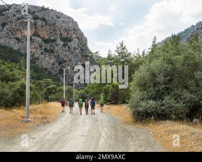 Touristen mit Rucksäcken laufen zum Goynuk Canyon. Wanderweg entlang der Berghänge im Beydaglari Coastal National Park. Truthahn. Stockfoto