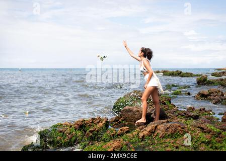 Salvador, Bahia, Brasilien - 02. Februar 2023: Gläubige der kamdongischen Religion halten Blumen für Iemanja in Salvador, Bahia, bereit. Stockfoto