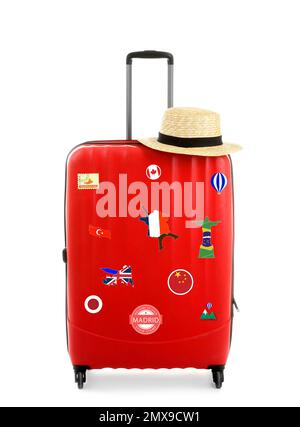 Roter Koffer mit Reiseaufklebern auf weißem Hintergrund Stockfoto