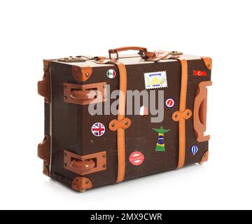 Retro-Koffer mit Reiseaufklebern auf weißem Hintergrund Stockfoto