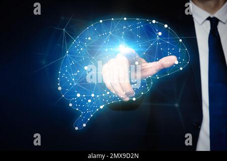 Junger Mann, der auf ein digitales Bild des Gehirns auf blauem Hintergrund zeigt, Nahaufnahme Stockfoto