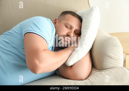 Fauler, übergewichtiger Mann, der zu Hause auf dem Sofa schläft Stockfoto