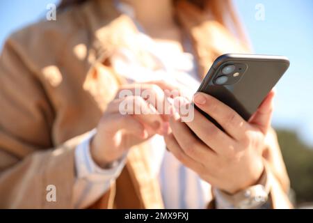 MYKOLAIV, UKRAINE - 16. MÄRZ 2020: Frau mit dem iPhone 11 Black im Freien, Nahaufnahme Stockfoto