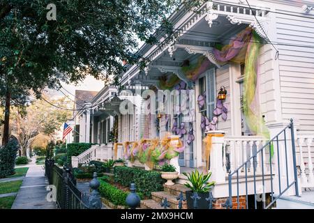 NEW ORLEANS, LA, USA - 31. JANUAR 2023: Eine Reihe historischer Shotgun-Doppelhäuser mit Mardi Gras-Dekorationen im Viertel Uptown Stockfoto