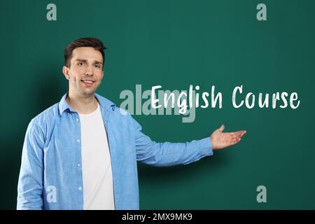 Porträt eines jungen Englischlehrers bei grüner Tafel Stockfoto