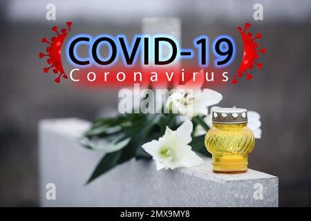 Beerdigungszeremonie für Coronavirus-Opfer. Weiße Lilien und Kerzen auf Grabstein im Freien Stockfoto