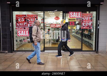 Manchester, Großbritannien. 2. Februar 2023. Am 2. Februar 2023 gehen die Leute an einem Geschäft mit Werbeschildern in Manchester vorbei. Die Bank of England (BoE) hob ihren Leitzins am Donnerstag um einen halben Prozentpunkt auf 4 Prozent an, das höchste Niveau seit Herbst 2008. Kredit: Jon Super/Xinhua/Alamy Live News Stockfoto