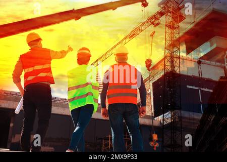 Professionelle Ingenieure in der Sicherheitsausrüstung auf der Baustelle, Rückansicht Stockfoto