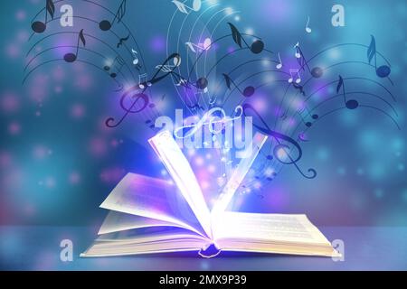 Symphonie mit musikalischen Noten aus einem offenen Buch auf farbigem Hintergrund Stockfoto