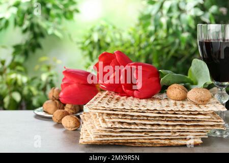 Traditionelle Matzos und Tulpen auf grauem Tisch. Pesach (Passover)-Feier Stockfoto