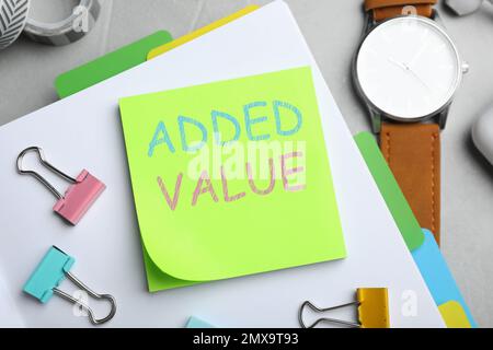 Mehrwert-Konzept. Flache Liegezusammensetzung mit Schreibwaren auf weißem Tisch Stockfoto