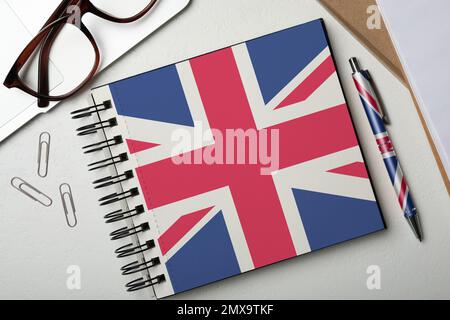 Elegantes Notebook und Stift auf weißem Tisch, flach liegend. Englisch Lernen Stockfoto
