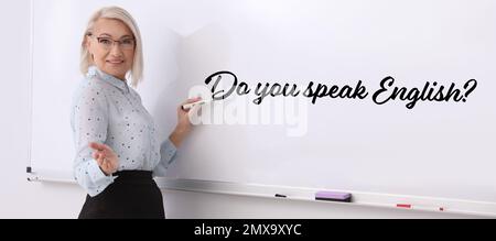 Reife Englischlehrer, die im Klassenzimmer auf einem Whiteboard schreiben. Bannerdesign Stockfoto