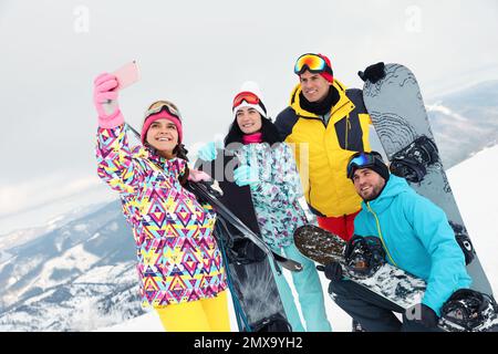 Eine Gruppe von Freunden macht Selfie in den schneebedeckten Bergen. Winterurlaub Stockfoto