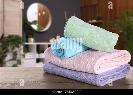 Frische Handtücher auf einem Holztisch im Badezimmer Stockfoto